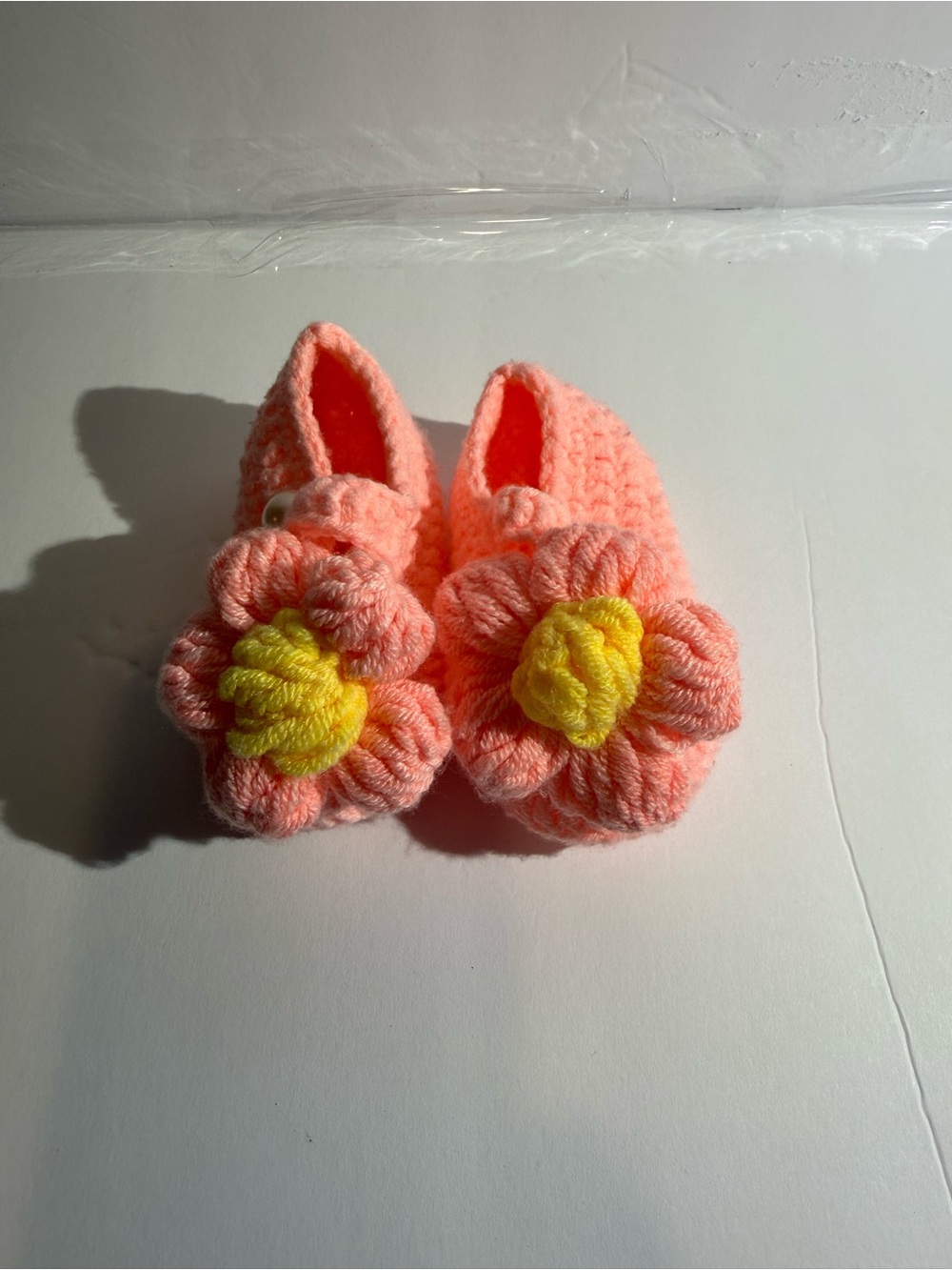 pink crochet baby shoes with flower details
